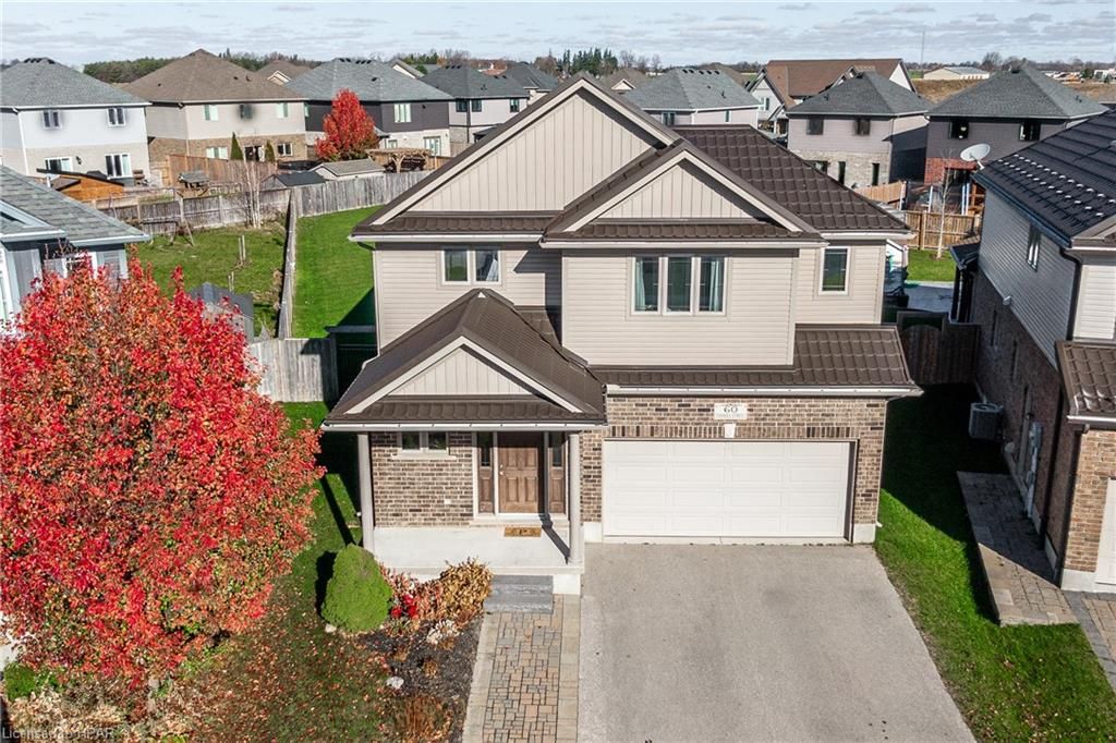 View of front of property with a garage and central AC unit