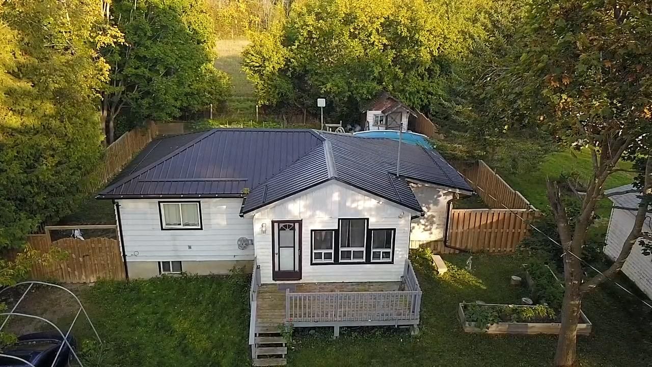 26 Laird Drive Kawartha Lakes, Ontario Welcome to your peaceful escape in the heart of Kawartha Lakes! This well-maintained 2-bedroom, 1-bath open-concept bungalow is perfect for first-time home buyers looking to get into the market, empty nesters seeking a low-maintenance retreat, or savvy investors eyeing a great location for short-term rental income. Set on a tranquil 75 x 200 ft lot, the home includes shared deeded access to the lake just a short walk away ideal for swimming, kayaking, or simply soaking in the waterfront lifestyle. Inside, the open-concept layout provides a bright and welcoming space, enhanced by new Lyonium flooring and underlay (2021), as well as cedar stairs installed the same year. The exterior is equally impressive, featuring a new steel roof, window facia and soffit (July 2023), a fully fenced yard with a double-wide gate (installed December 2021), and a dedicated dog run perfect for pet owners or families with children. Whether you're enjoying quiet mornings in the yard, hosting friends and family, or welcoming guests through a short-term rental, this home offers incredible versatility in a sought-after location. Dont miss this opportunity to own a charming, move-in ready bungalow with lake access book your private showing today!