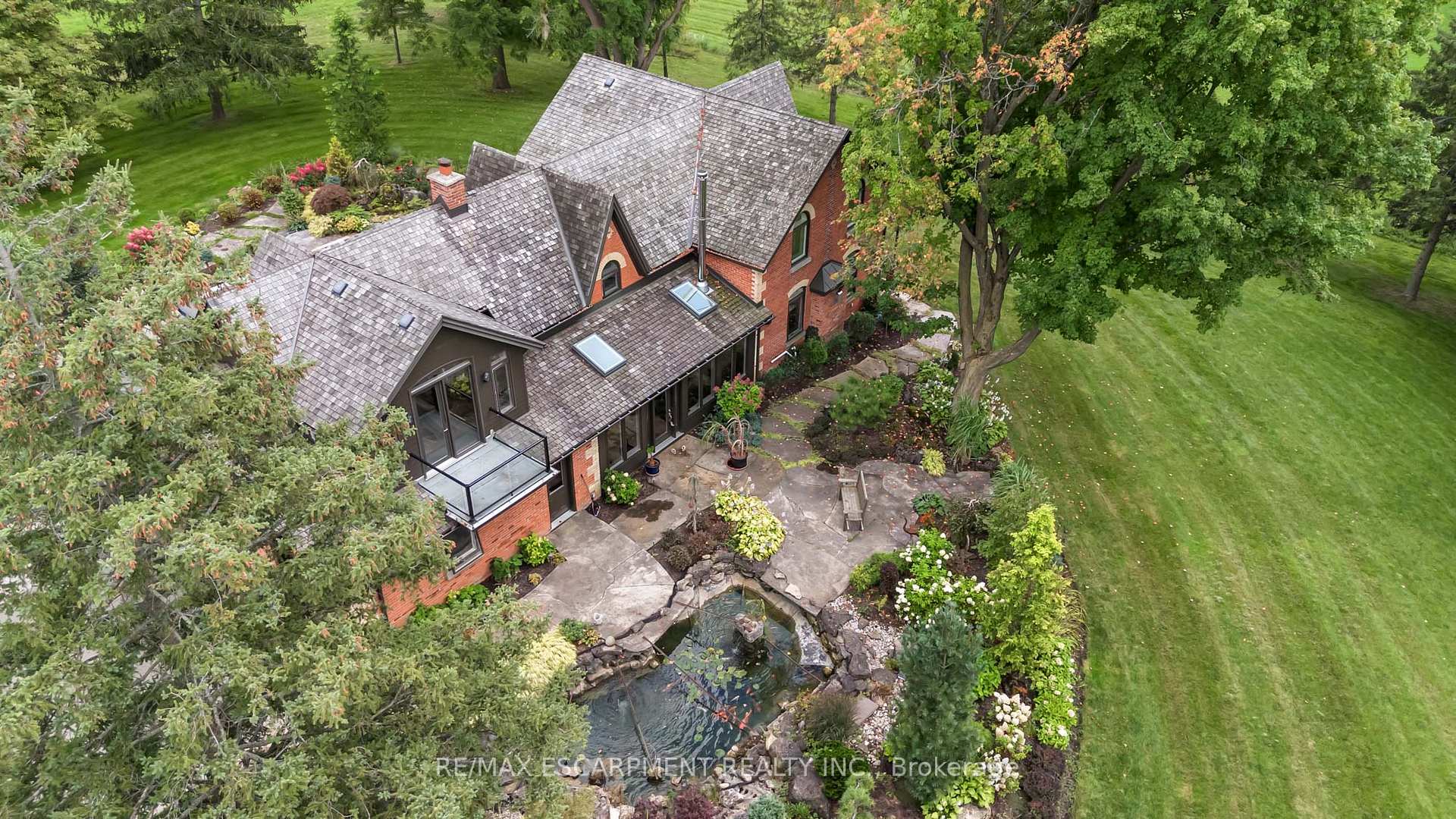 1399 Safari Road Hamilton, Ontario Nestled amidst rolling hills and lush countryside, welcome to a place where dreams of idyllic country living come true. This unique property is located on 51+ acres of stunning farmland with two large barns and a picturesque pond with serene waterfall and dock. The perfect mixture of rustic and modern flare, this home boasts 3000+ square feet of living space and has been renovated from top to bottom. Enter the main doors to your light filled sanctuary. The custom kitchen is a chefs dream complete with Jenn-Air wall ovens, integrated Kitchen Aid double fridge and Thermador six burner double wide range. There are five bedrooms including an extensive and private primary retreat with balcony overlooking the beautiful grounds. The ensuite features a large soaker tub, steam shower, heated floors, and separate vanity. Entertain guests with comfort and ease in the second primary suite, complete with ensuite and walk-in closet. Outdoors you will find two large barns, one complete with garage door, man door, wood burning fireplace and concrete floors- a car lovers delight. The 2nd features high ceilings, large window and sliding door and is awaiting your personal touch. This home is packed with so many updates and upgrades. RSA.