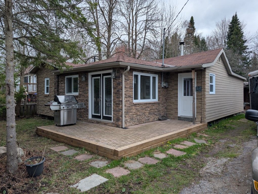 1088 Balsam Road Innisfil, Ontario Steps to Lake Simcoe with community beach access. Welcome to this wonderful waterfront community of Belle Ewart and a great opportunity for first time buyers. This 2 bedroom home featues great curb appeal and tons of upgrades and updates including electrical, windows, wood flooring, ceramic tile and newer kitchen with granite counter tops and upgraded solid wood cabinets. Heated with a woodstove and with seperately zoned thermostatically controlled electric wall heaters and high efficiency baseboards. Exterior is a combination of James Hardy siding (cement fibre) and Polyroche stone facing, This is a perfect neighbourgood for young families and retirees alike. Close to the lake, shopping, restaurants, schools, golf, ice fishing and so much more. This property features lots of mature trees providing privacy in the almost fully fenced yard. Just move in and enjoy!